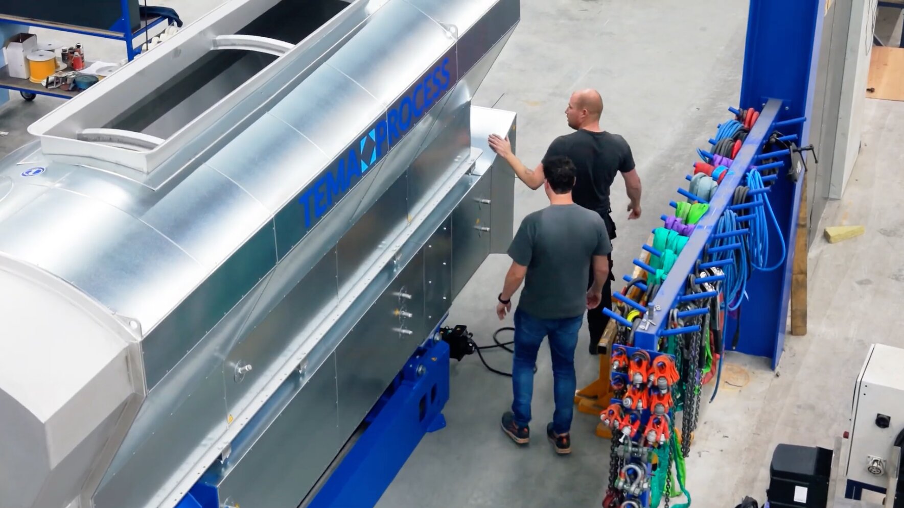 Twee medewerkers bij een machine met verzinkt afwerkplaatwerk en het opschrift TEMA PROCESS